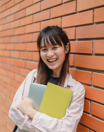 Happy student carries course materials bought in a bookstore